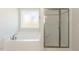 Bathroom featuring soaking tub, glass enclosed shower and natural light at 157 Newport Landing # 95, Garner, NC 27529