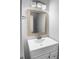 The vanity features a sink, gold-trimmed mirror, updated fixtures and vanity lighting at 1432 Quarter Pt, Raleigh, NC 27615