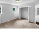 This bright bedroom features a window, plush carpeting, and a closet for ample storage at 1432 Quarter Pt, Raleigh, NC 27615