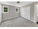 Bright bedroom with gray walls, carpeted floor, closet, and two windows providing natural light at 1432 Quarter Pt, Raleigh, NC 27615
