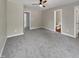 Spacious bedroom with gray carpet, ceiling fan, and open doorways to the bathroom and hallway at 1432 Quarter Pt, Raleigh, NC 27615