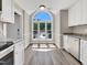 Bright dining area featuring white cabinets, granite counters, and a large arched window at 1432 Quarter Pt, Raleigh, NC 27615