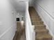 View of the home's entryway with staircase and doorway leading to a bright living area with wood flooring at 1432 Quarter Pt, Raleigh, NC 27615