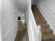 View of the home's entryway with staircase and doorway leading to a bright living area with wood flooring at 1432 Quarter Pt, Raleigh, NC 27615