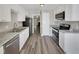 Modern kitchen with stainless steel appliances, granite countertops, and sleek white cabinets at 1432 Quarter Pt, Raleigh, NC 27615