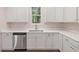 Bright kitchen with stainless steel dishwasher, white cabinets and countertops, and a window at 146 Wood Wedge, Sanford, NC 27332