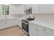 Modern kitchen with stainless steel appliances, white cabinets and countertops, and recessed lighting at 146 Wood Wedge, Sanford, NC 27332