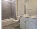Modern bathroom featuring gray tiled shower and tub, toilet and vanity with white cabinets at 3006 Freewinds Way # 41, Cary, NC 27519