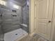 Modern shower with glass door and gray tile surround, with a built-in niche and bench at 3006 Freewinds Way # 41, Cary, NC 27519