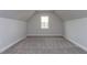 This attic features neutral carpet and a window to let in natural light and offer a view of the neighborhood at 111 Gaines Trail, Pittsboro, NC 27312