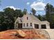 Charming new construction home featuring a two-car garage, lush trees, and a paved driveway under a blue sky at 111 Gaines Trail, Pittsboro, NC 27312