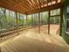 Screened-in porch with wood flooring and railings offering a view of the wooded backyard at 111 Gaines Trail, Pittsboro, NC 27312