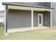 Covered porch with gray siding, white columns and trim, and a door leading to the backyard at 136 Newport Lndg, Garner, NC 27529