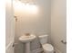 A half bathroom with a pedestal sink and a white toilet at 136 Newport Lndg, Garner, NC 27529