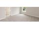 Bright bedroom with neutral carpet, window, white walls and trim, and an en suite bathroom entrance at 136 Newport Lndg, Garner, NC 27529