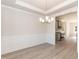 Elegant dining room with modern chandelier, wood floors, and access to the kitchen at 136 Newport Lndg, Garner, NC 27529