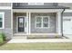 Inviting entryway featuring stone accents, a black front door, and a well-maintained lawn showcasing the home's charm at 136 Newport Lndg, Garner, NC 27529