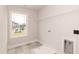 Bright laundry room featuring tile floor, window, washer and dryer hookups, and wire shelving at 136 Newport Lndg, Garner, NC 27529