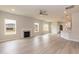 Open-concept living room with wood floors, a fireplace, and a view of the kitchen, perfect for entertaining at 136 Newport Lndg, Garner, NC 27529