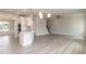 Bright living room with wood floors, a kitchen island, and staircase creating a welcoming and functional space at 136 Newport Lndg, Garner, NC 27529