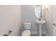 Powder room features a pedestal sink, round mirror, and neutral paint at 136 Newport Lndg, Garner, NC 27529