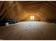 Spacious unfinished attic featuring wood beams, insulation, and a single window at 162 Gaines Trail, Pittsboro, NC 27312