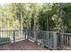The back deck is made of wood and has railings that provide a view of the trees at 162 Gaines Trail, Pittsboro, NC 27312