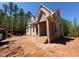 New two story home featuring brick and siding exterior, a covered porch, and a partially completed yard at 162 Gaines Trail, Pittsboro, NC 27312
