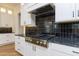 Chef's kitchen with black backsplash and stainless steel gas range at 162 Gaines Trail, Pittsboro, NC 27312