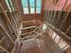 Unfinished stairwell featuring wood framing, pink insulation, and multiple windows at 162 Gaines Trail, Pittsboro, NC 27312