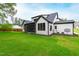 Lush backyard view of the home's rear exterior featuring green grass and mature trees at 5812 Shawood Dr, Raleigh, NC 27609