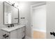 Modern bathroom featuring a white vanity with black fixtures, and a view into the bedroom at 5812 Shawood Dr, Raleigh, NC 27609