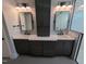 Modern bathroom with dual vanity, sleek gray cabinets, and bright lighting fixtures at 5812 Shawood Dr, Raleigh, NC 27609