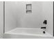 Modern bathroom with white tiled walls, a sleek tub, and black fixtures at 5812 Shawood Dr, Raleigh, NC 27609
