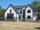Striking modern farmhouse with crisp white siding, black accents, and manicured lawn at 5812 Shawood Dr, Raleigh, NC 27609
