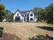 Stunning two-story home with white siding, black trim, and mature trees at 5812 Shawood Dr, Raleigh, NC 27609
