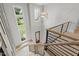 Bright foyer with hardwood stairs, modern railing, and natural light at 5812 Shawood Dr, Raleigh, NC 27609