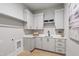 Well-lit laundry room features shaker style cabinets, a modern black faucet, and a sleek countertop with ample space at 5812 Shawood Dr, Raleigh, NC 27609