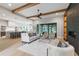 Open-concept living space with wood beams, leading to a modern kitchen and dining area, with a cozy fireplace at 5812 Shawood Dr, Raleigh, NC 27609