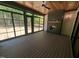 Screened porch with a wooden ceiling, black-framed windows, and a gray brick fireplace at 5812 Shawood Dr, Raleigh, NC 27609