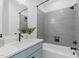 Well lit bathroom features modern tiling, blue vanity, and shower with dark fixtures at 610 Rocky Knob Ct, Raleigh, NC 27601