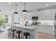 Gourmet kitchen featuring white cabinets, marble countertops, a kitchen island and modern stainless steel appliances at 610 Rocky Knob Ct, Raleigh, NC 27601