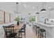 Bright, open-concept living space with hardwood floors and modern lighting is connected to the kitchen and dining area at 610 Rocky Knob Ct, Raleigh, NC 27601