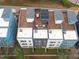 Aerial view of modern townhomes with rooftop decks and solar panels, nestled in a suburban setting at 614 Rocky Knob Ct, Raleigh, NC 27601