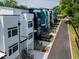 Stylish modern townhomes line a street with eye-catching colors, sleek stairs, and landscaped yards at 614 Rocky Knob Ct, Raleigh, NC 27601