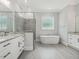 Spa-like bathroom with soaking tub, frameless glass shower, double vanities, and tile flooring at 139 Goodison Park Rd, New Hill, NC 27562