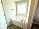Bright bathroom with a large soaking tub under a window at 156 Southern Estates Dr, Sanford, NC 27330