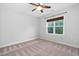 Bedroom featuring ceiling fan, a window overlooking greenery, neutral carpet, creating a relaxing ambiance at 277 High Ridge Ln, Pittsboro, NC 27312