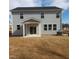 Rear exterior featuring light gray siding, covered patio, and sliding glass doors to the grassy backyard at 39 Longdale Dr, Graham, NC 27253