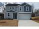 Charming two-story home with light gray siding, blue accents, and a spacious two-car garage at 39 Longdale Dr, Graham, NC 27253